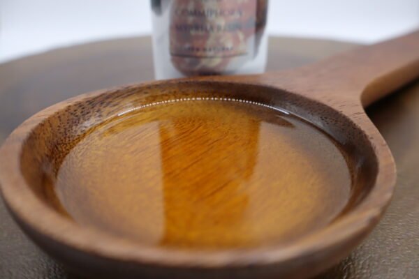 cuchara decorativa de madera llena de aceite de mirra