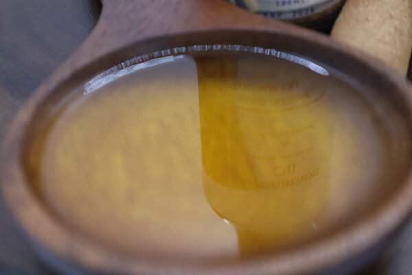 una cuchara de madera lleno de aceite de canela
